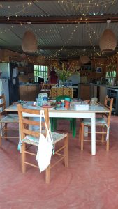 Image of rustic kitchen with tables, chairs and the usual kitchen appliances