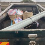 Image of back of pickup truck. It has lots of shoppingtied down in the back.
